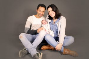 Familienfoto mit Baby mit grauem Hintergrund