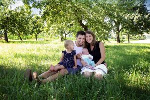 Familie im Gras sitzend beim Familienshooting in Farbe
