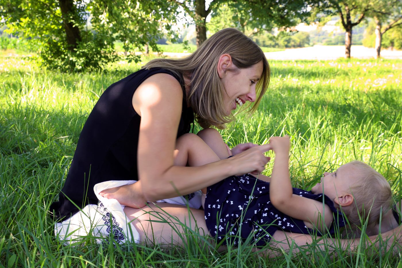 Mutter mit Kind liegend im Gras beim Familienshooting