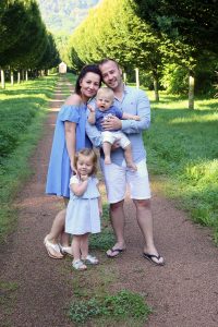 Glückliche Familie vor Baumallee fotografiert