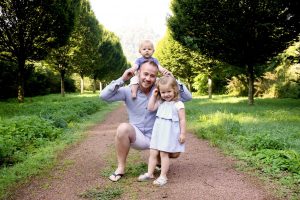 Vater mit Kind knieend mit Kind auf der Schulter abgelichtet