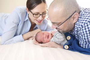 Mutter und Vater betrachten glückliches Baby