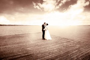 Brautpaar steht auf Floss inmitten des Bodensees in Sepia