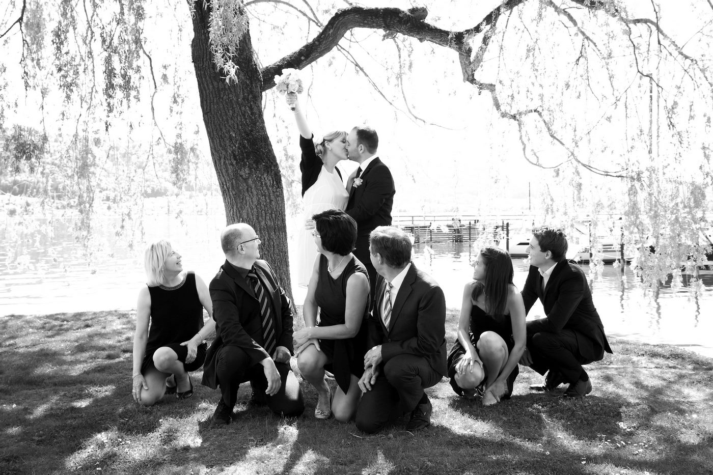 Braut in Siegerpose mit Eltern und Trauzeugen in schwarz-weiß fotografiert