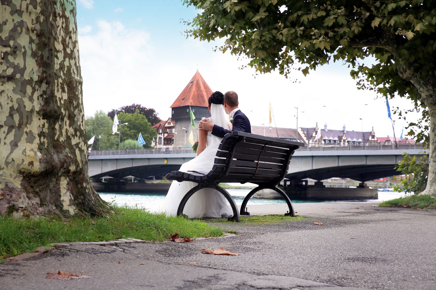 Brautpaar sitzend am Rheinufer mit Blick auf Konstanz