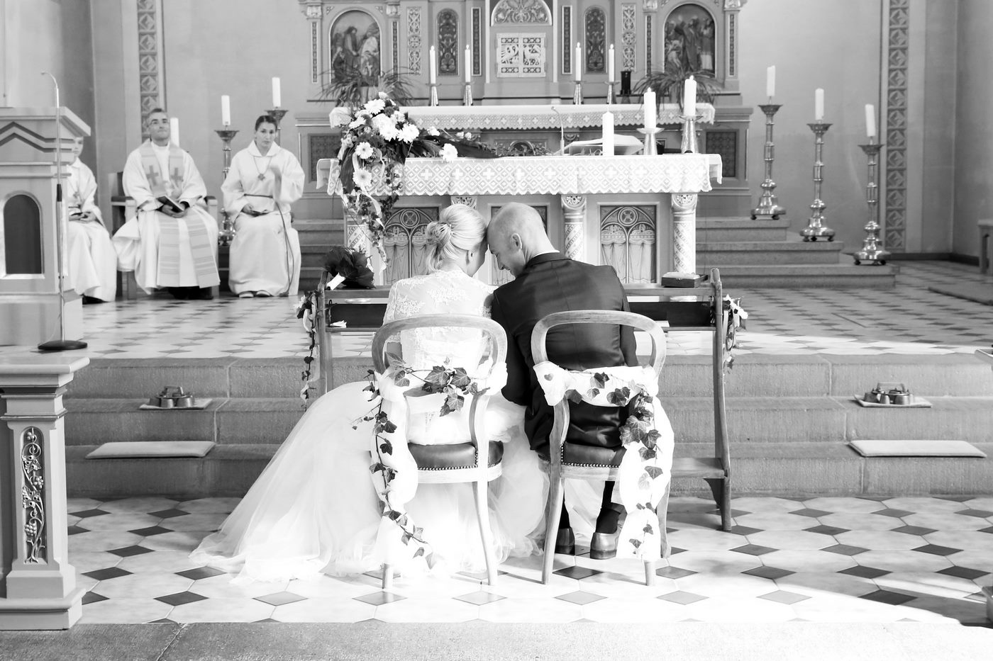 Brautpaar vor dem Altar in der Kirche sitzend