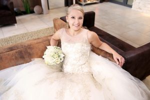 Braut ganz in weiß sitzend im Sofa