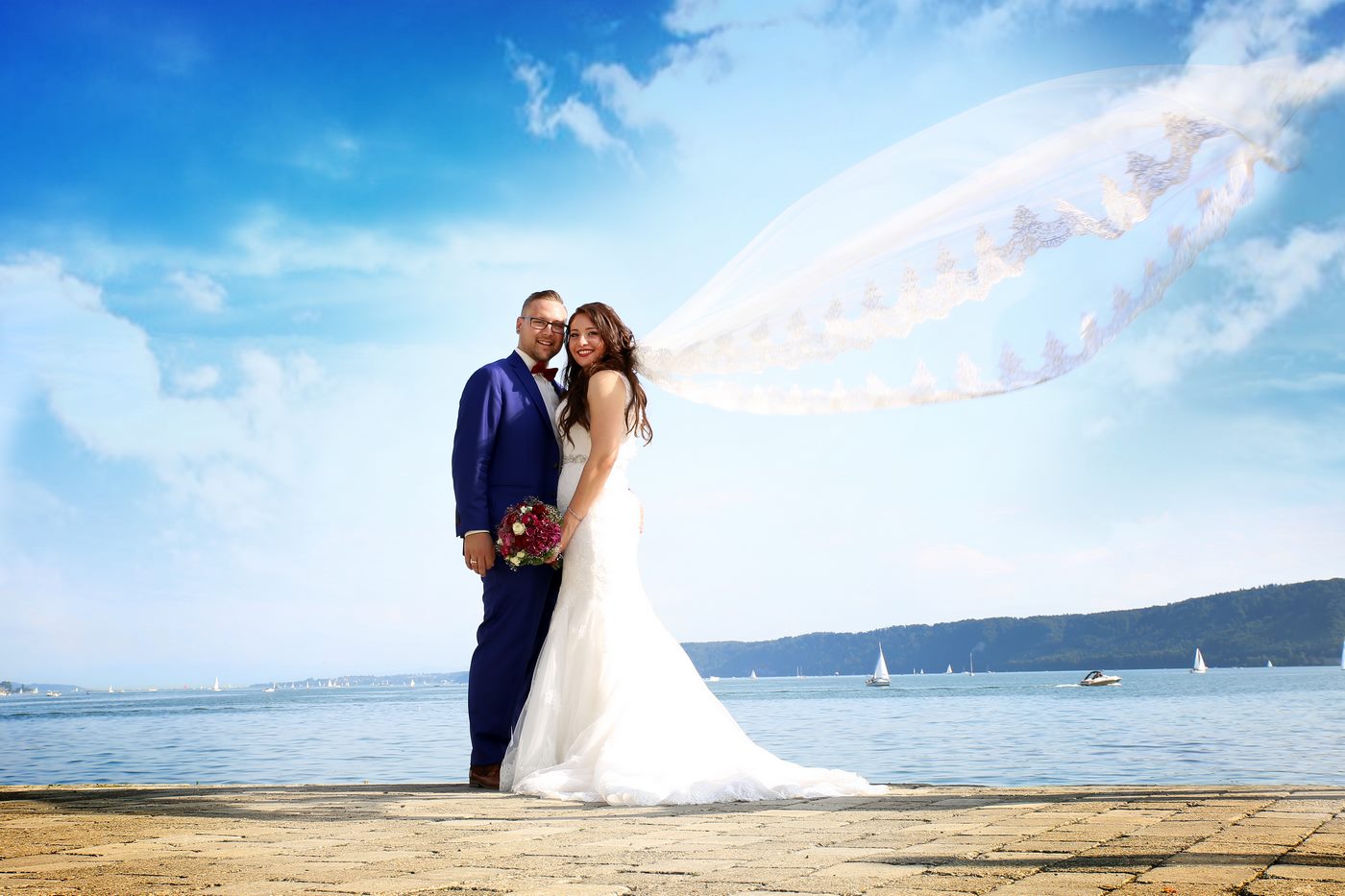 Brautpaar am Bodensee fotografiert und der Schleier weht im Wind
