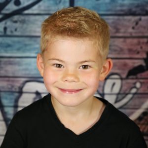 Junge lacht im Kindergarten und wird fotografiert
