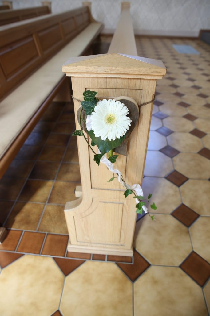 Blumenschmuck in der Kirche an heller Bank