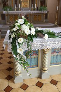 Großes Blumengesteck an einer Ecke des Kirchenaltars