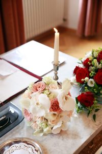 Blumenstrauß neben brennender Kerze