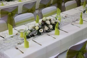 Tischdekoration in Grün mit Blumengesteck