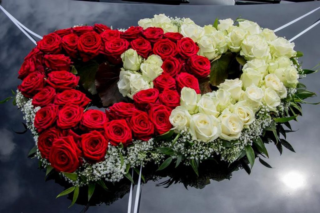 Auto Blumenschmuck in Form von zwei Herzen in weiß-rot auf einem schwarzem Mercedes