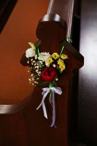 Blumenanhänger an Kirchenbank mit grünem Band