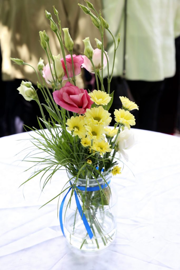 Blumen in Vase mit blauem Band