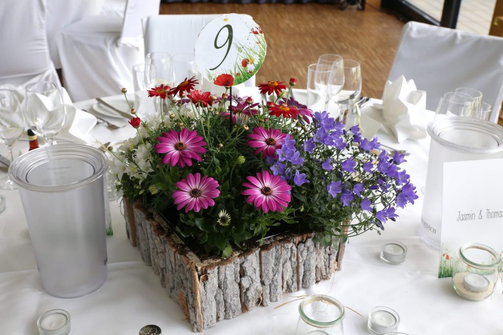 Blumenschmuck in Lila bepflanzt mit Tischnummer