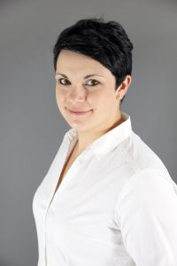 Jungefrau mit beim Businessshooting vor grauerm Hintergrund