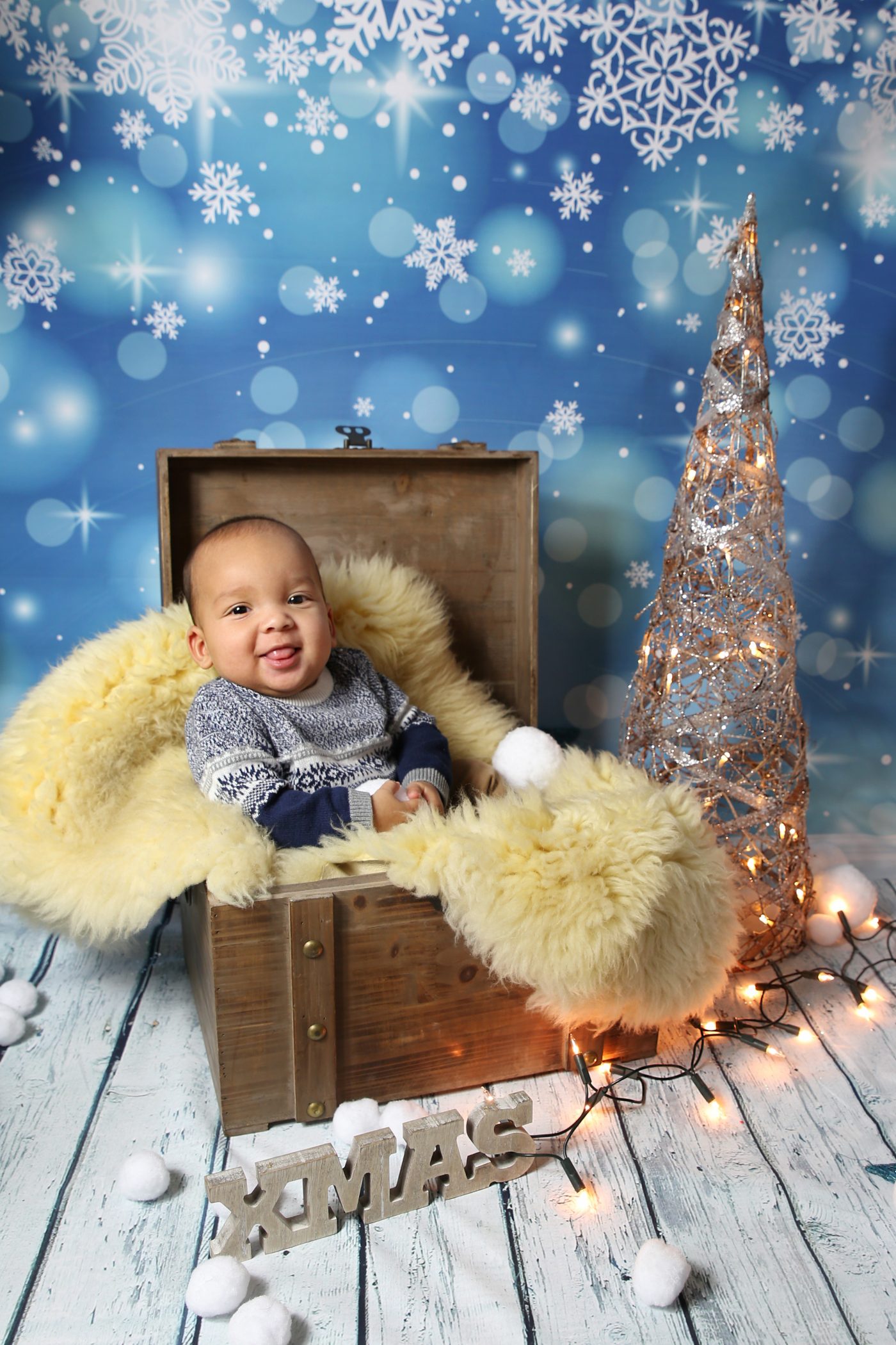 Baby fotografiert in Holzkiste zur Weihnachtszeit