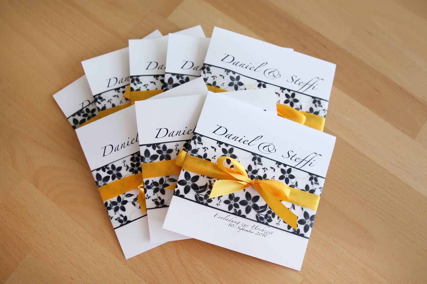 Einladungskarte zur Hochzeit mit Satinschleife und Blumenmuster