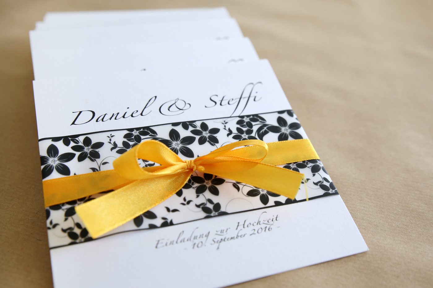 Einladungskarte zur Hochzeit mit Satinschleife und Blumenmuster
