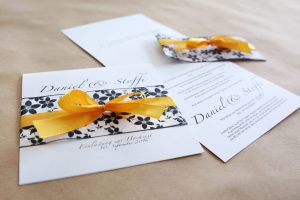 Einladungskarte zur Hochzeit mit Satinschleife und Blumenmuster