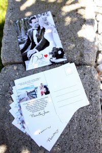 Einladungskarte zur Hochzeit als Postkarte in schwarz-weiß auf Steinmauer