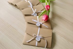 mehrere Pocketfold Einladungskarten mit weißem Satinband